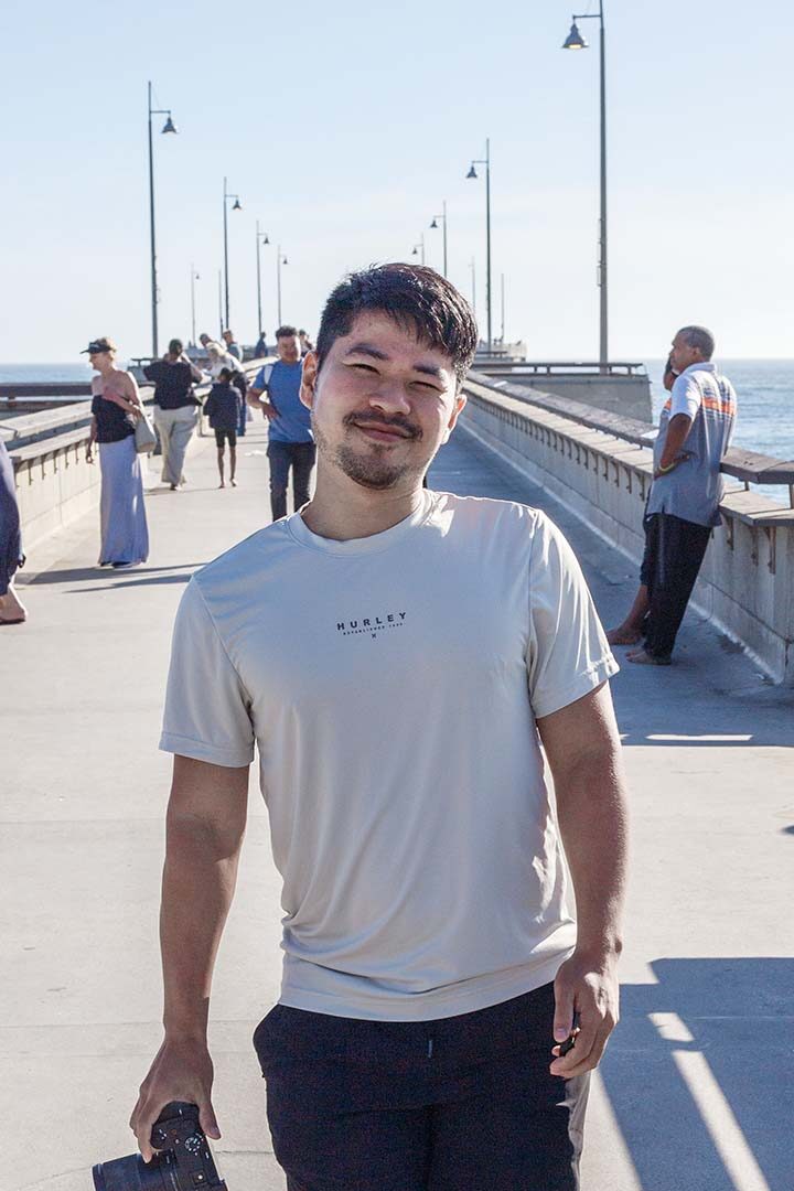 Manachai on a pier with a camera